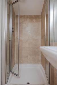 La salle de bains est pourvue d'une douche avec une porte en verre. dans l'établissement Spacious 3 Bedroom Regents Park Apartment, à Londres