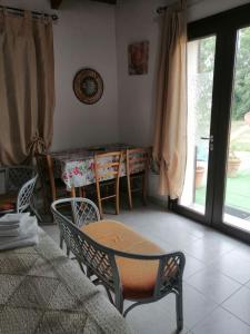 een kamer met een tafel en stoelen en een tafel en ramen bij Camera Serraona in Alghero