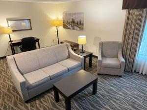 uma sala de estar com um sofá e uma cadeira em Best Western Plus Valdosta Hotel & Suites em Valdosta