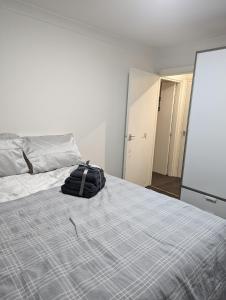 a bedroom with a bed with a backpack on it at Modern ground floor flat in Cranford