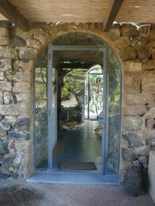 einen Eingang zu einem Steingebäude mit Torbogen in der Unterkunft Antico Dammuso Venedisè in Pantelleria