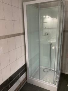 W łazience znajduje się prysznic ze szklanymi drzwiami. w obiekcie Le Sarment w mieście Sainte-Menehould
