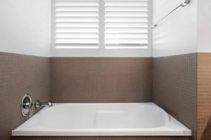 une baignoire dans une salle de bain avec une fenêtre dans l'établissement Exceptional Luxury ~ Broadwater Beauty ~ Free Parking ~ Top Location, à Gold Coast 18 autres photos
