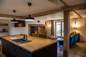 a kitchen with a wooden counter top and a living room at Keepers Lodge in Knowstone