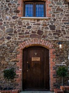 een toegang tot een bakstenen gebouw met een houten deur bij Keepers Lodge in Knowstone