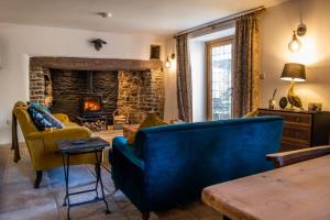 a living room with a blue couch and a fireplace at Keepers Lodge in Knowstone