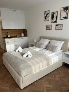 a bedroom with a large bed with towels on it at Apartament Planeta 106 - tylko 100 m od plaży in Mielno