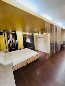 a bedroom with a large bed and a flat screen tv at Walker Motel in Taipei