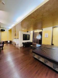 Walker Motel في تايبيه: غرفة معيشة كبيرة بها سرير وتلفزيون