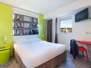 1 dormitorio con 1 cama grande y escritorio en ibis Styles Cannes Le Cannet en Cannes