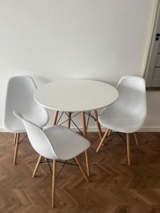 a white table and four white chairs in a room at Apartament Planeta 106 - tylko 100 m od plaży in Mielno