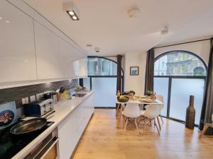 a kitchen with a table and chairs in a room at Shard View Apartments in London