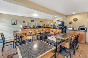 a restaurant with tables and chairs and a kitchen at Best Western Americana Inn in San Ysidro, San Diego