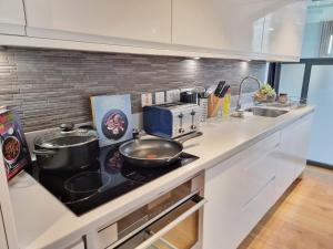 a kitchen with a counter top with a frying pan on a stove at Shard View Apartments in London