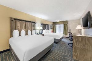 Habitación de hotel con 2 camas y TV de pantalla plana. en Best Western Americana Inn, en San Ysidro