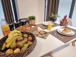 a table with a basket of fruits and vegetables on it at Shard View Apartments in London