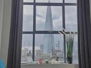 a window with a view of the shard in a city at Shard View Apartments in London