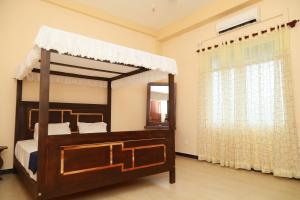 a bedroom with a canopy bed and a window at Multi Villa Gold in Galle