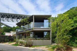a glass house with a bridge in the background at Seaside Villa SEEN Deep Sea in Onomichi