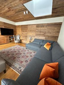 sala de estar con sofá azul y TV en 423 - Penthouse apartment centrum Mayrhofen near ski area en Mayrhofen