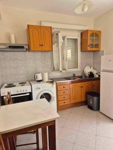 a kitchen with a white stove top oven next to a refrigerator at DESPINA SGPP in Argostoli