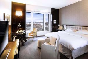 a hotel room with a bed and a desk and a window at Grand Hyatt Berlin in Berlin