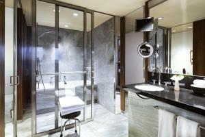 y baño con ducha acristalada y lavamanos. en Grand Hyatt Berlin en Berlín