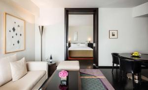 ein Wohnzimmer mit einem Sofa, einem Tisch und einem Bett in der Unterkunft Grand Hyatt Berlin in Berlin