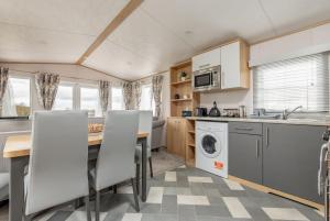 uma cozinha e sala de jantar com mesa e cadeiras em Lodge 10 The Silverdale Close to St Andrews em St Andrews
