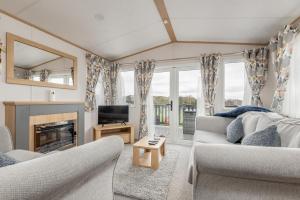 uma sala de estar com dois sofás e uma televisão em Lodge 10 The Silverdale Close to St Andrews em St Andrews