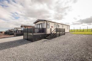 a row of tiny houses on a gravel lot at Lodge 10 The Silverdale Close to St Andrews in St. Andrews