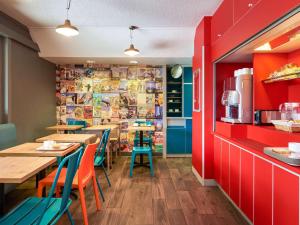 a restaurant with tables and chairs and red walls at hotelF1 Thonon Les Bains Est in Marin