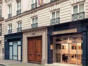 un grand bâtiment avec un hôtel mercure dans une rue dans l'établissement Mercure Paris Opera Grands Boulevards, à Paris