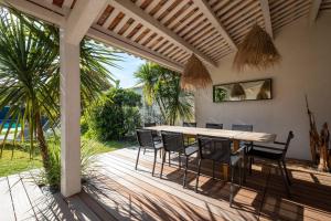 a wooden deck with a table and chairs on it at BEACH HOUSE in Les Grenettes
