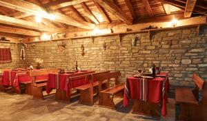 a restaurant with tables and chairs and a brick wall at Yovina House Zheravna in Zheravna