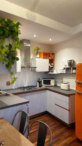 a kitchen with white cabinets and a table with chairs at Floorplan B - 208 in Turin