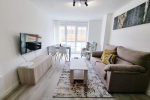 a living room with a couch and a table at VibesMalpica - Canido 12 in Malpica