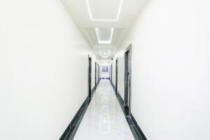 an empty corridor in a building with white walls and ceilings at FabHotel Prime SM Resort in Bhopal