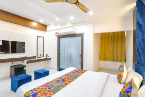 a bedroom with a bed and blue stools in it at FabHotel Prime SM Resort in Bhopal