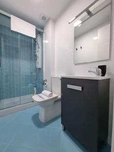 een badkamer met een toilet, een wastafel en een douche bij VibesCoruña- Malpica in Malpica