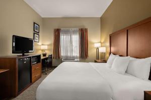 a hotel room with a large bed and a flat screen tv at Comfort Inn Ogden near Event Center in Ogden
