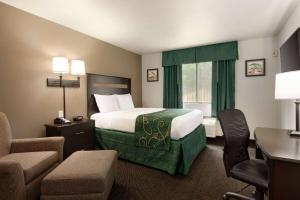 a hotel room with a bed and a desk and chairs at Travelodge by Wyndham Hermiston in Hermiston