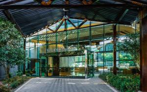 a glass building with a walkway in front of it at UrCove by Hyatt Shanghai Pudong East in Shanghai