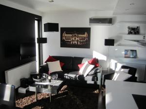 uma sala de estar com um sofá preto e almofadas vermelhas em Penthouse mit Donaublick em Budapeste