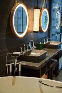 a bathroom with two sinks and three mirrors at Andaz Bali - a Concept by Hyatt in Sanur