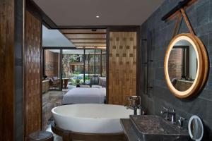 a bathroom with a bath tub and a bedroom at Andaz Bali - a Concept by Hyatt in Sanur