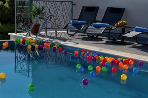 una piscina con bolas de colores en el agua en Luxury Apartments Podgora, en Podgora