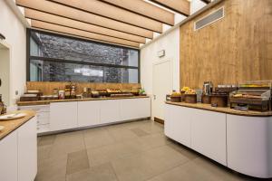 a large kitchen with white cabinets and a large window at Best Western Plus Hotel De Capuleti in Verona