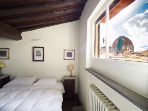 1 Schlafzimmer mit 2 Betten und einem Fenster in der Unterkunft Apt in Via Ginori in a historical palazzo with elevator in Florenz