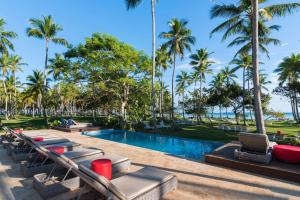 una piscina en el complejo con tumbonas y palmeras en Wyndham Alltra Samana All Inclusive Resort, en Las Galeras